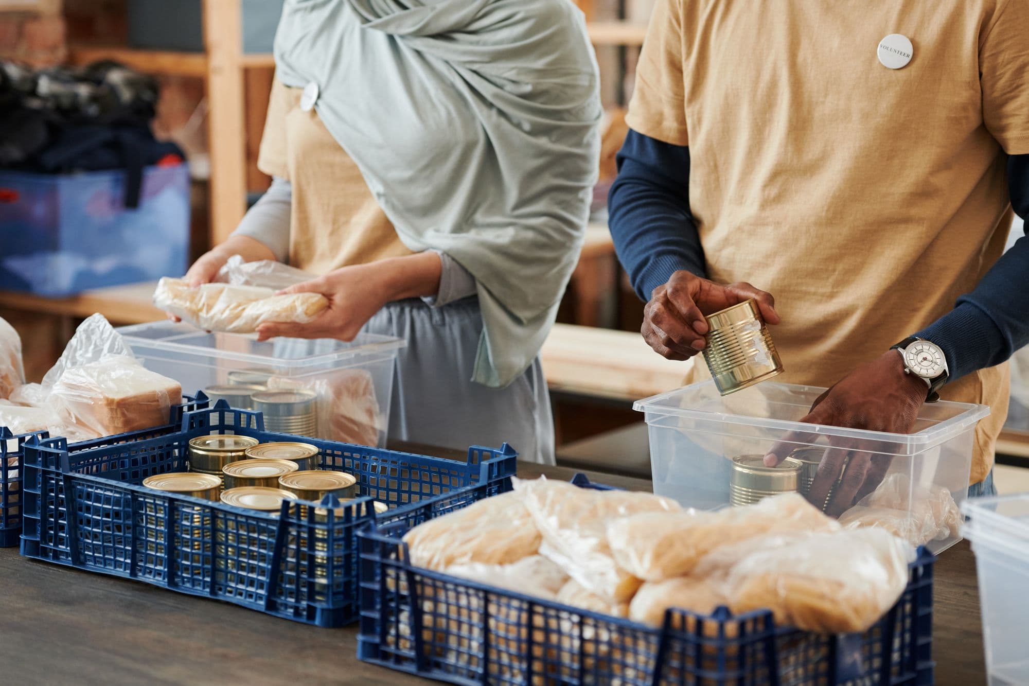 Volunteers sorting boxes of donated food into crates at a community pantry