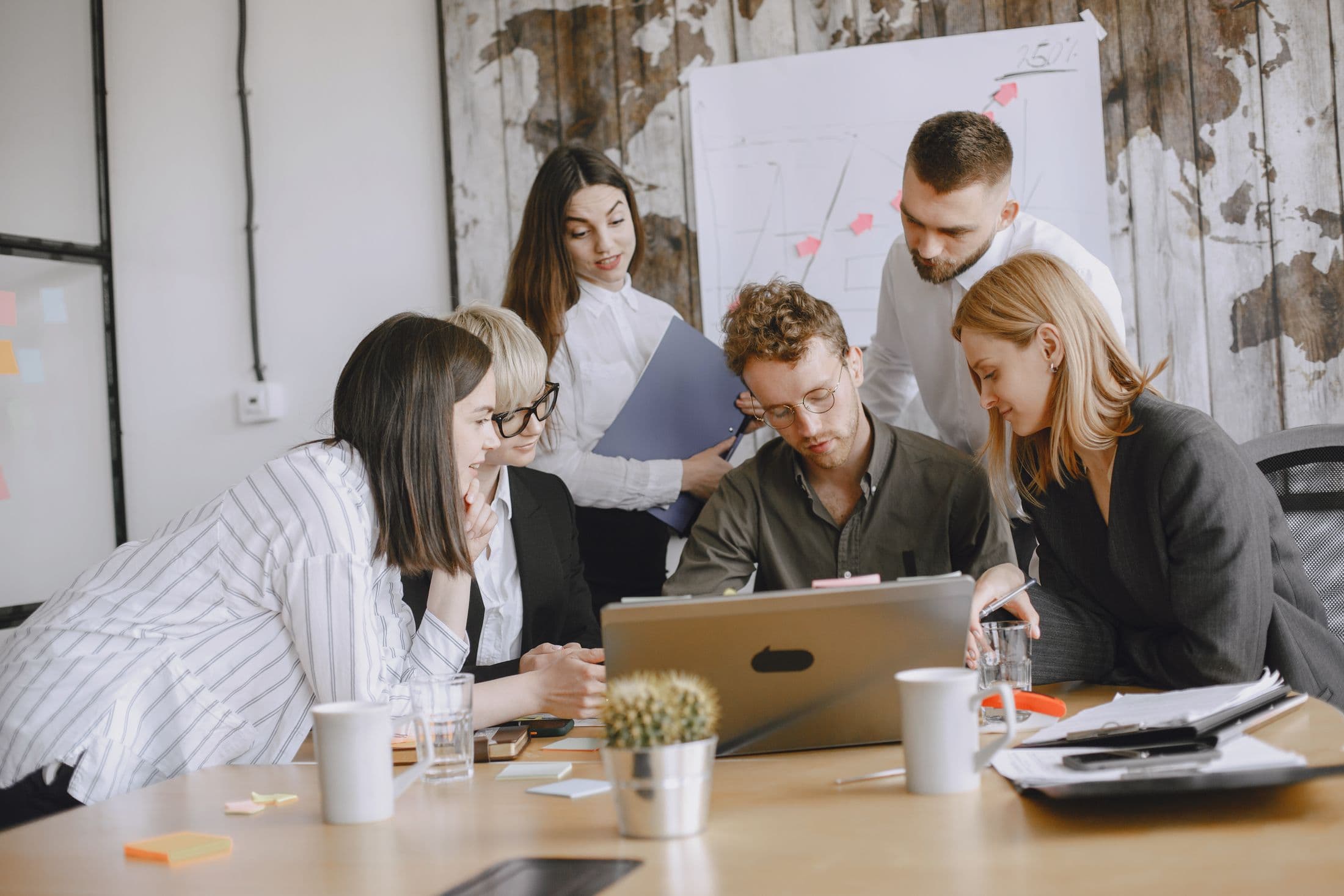 A small nonprofit team gathered around a laptop, planning together
